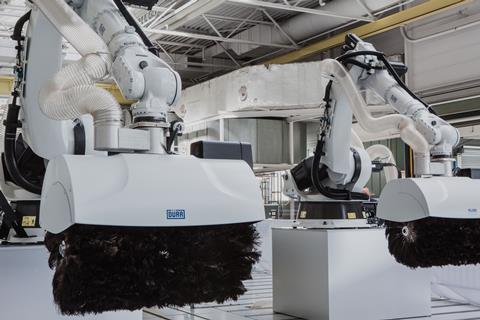 Feather-roller robots clean vehicle bodies of dust and debris before painting, adapting to BYD's diverse EV designs and production sequences.